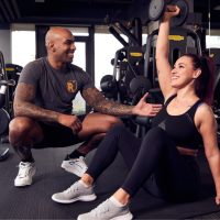 Ein Mann und eine Frau trainieren in einem Fitnessstudio.