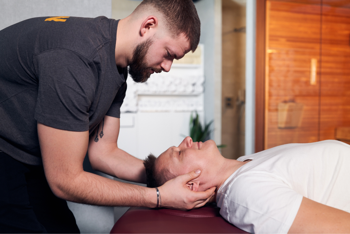 Ein Mann lässt sich in Frankfurt von einem Massagetherapeuten den Nacken massieren.