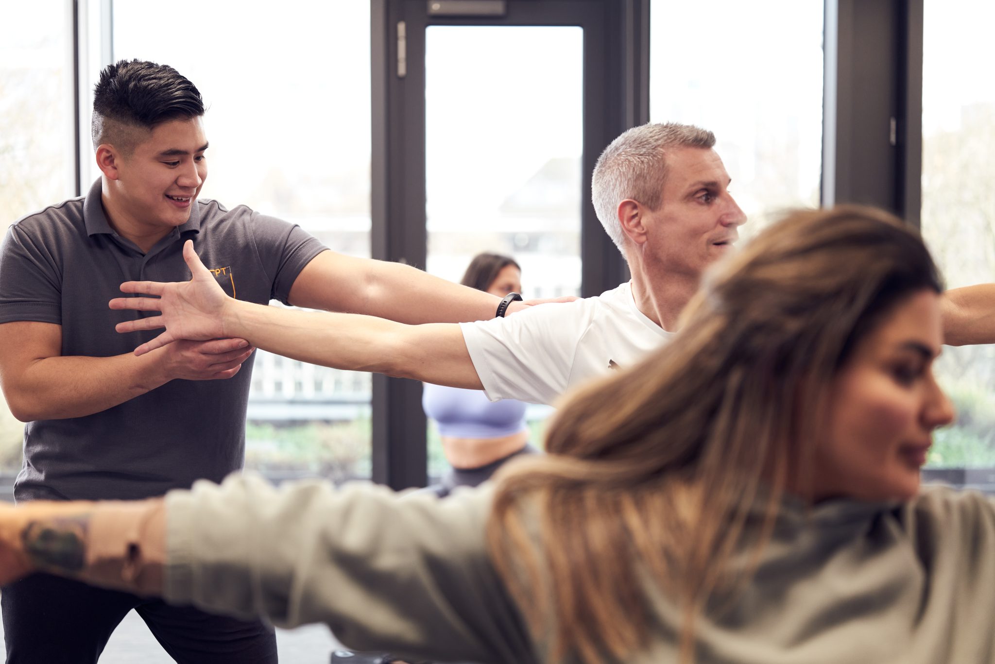 Eine Gruppe von Menschen macht Yoga in einem Fitnessstudio.
